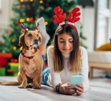 Adolescente allongée devant un sapin de Noël avec son chien