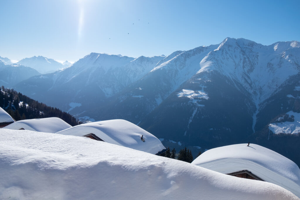 Toits de chalets suisses enneigés sous le soleil