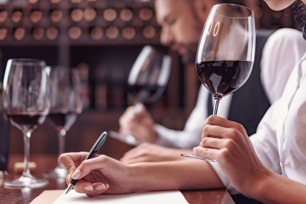 Sommeliers dégustant du vin rouge et prenant des notes