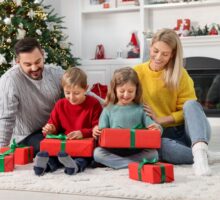 Des enfants ouvrent leurs cadeaux de Noël à la maison avec leurs parents