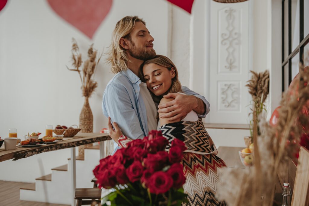 Jeune couple romantique s'embrassant lors de la célébration de la saint-valentin dans une maison décorée.