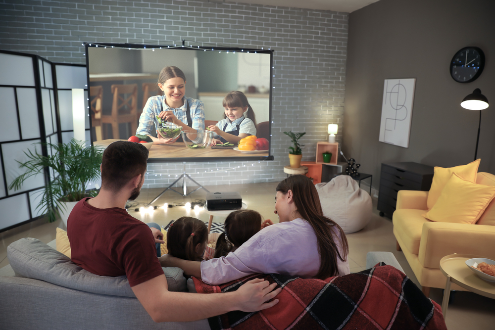 Jeune famille regardant un film à la maison le jour de la fête des mères.