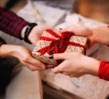 Un homme offre un cadeau de noel à une femme qu'il connaît peu.