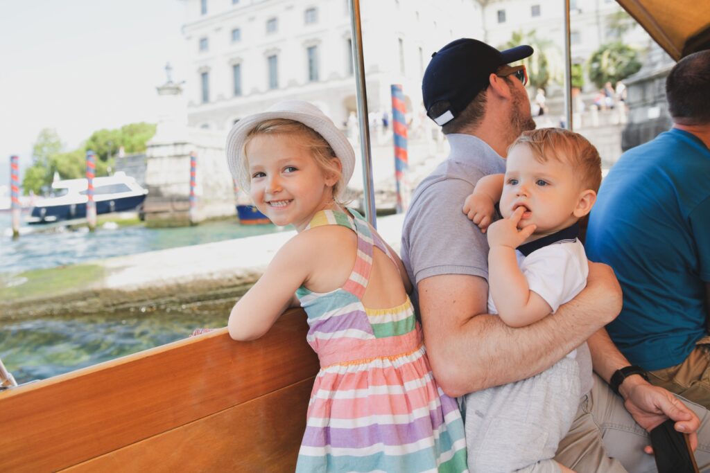 Père et enfants sur un bateau sur le lac Majeur naviguant vers l'île d'Isola Bella à l'occasion de la fête des pères.