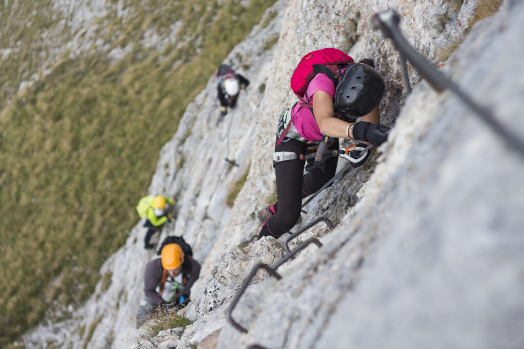 Grupo de personas escalando via ferrata