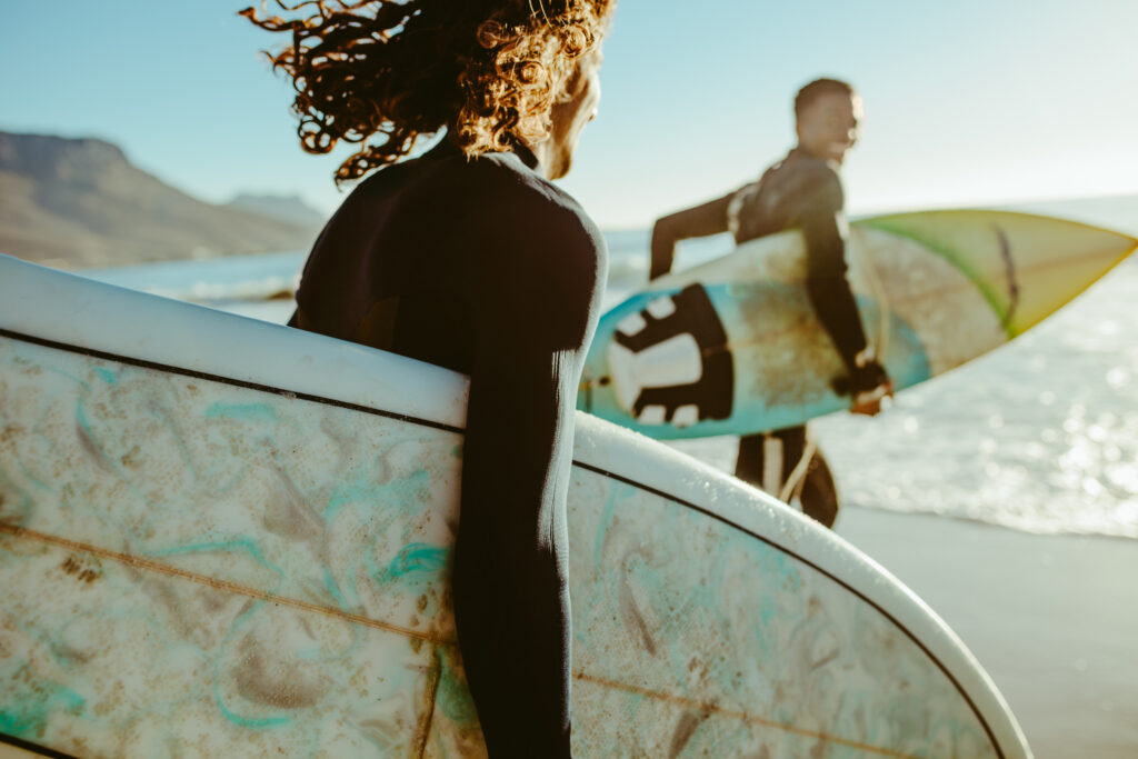 Pareja de surfistas felices en la playa