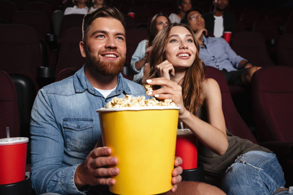 Pareja viendo película con palomitas y refrescos