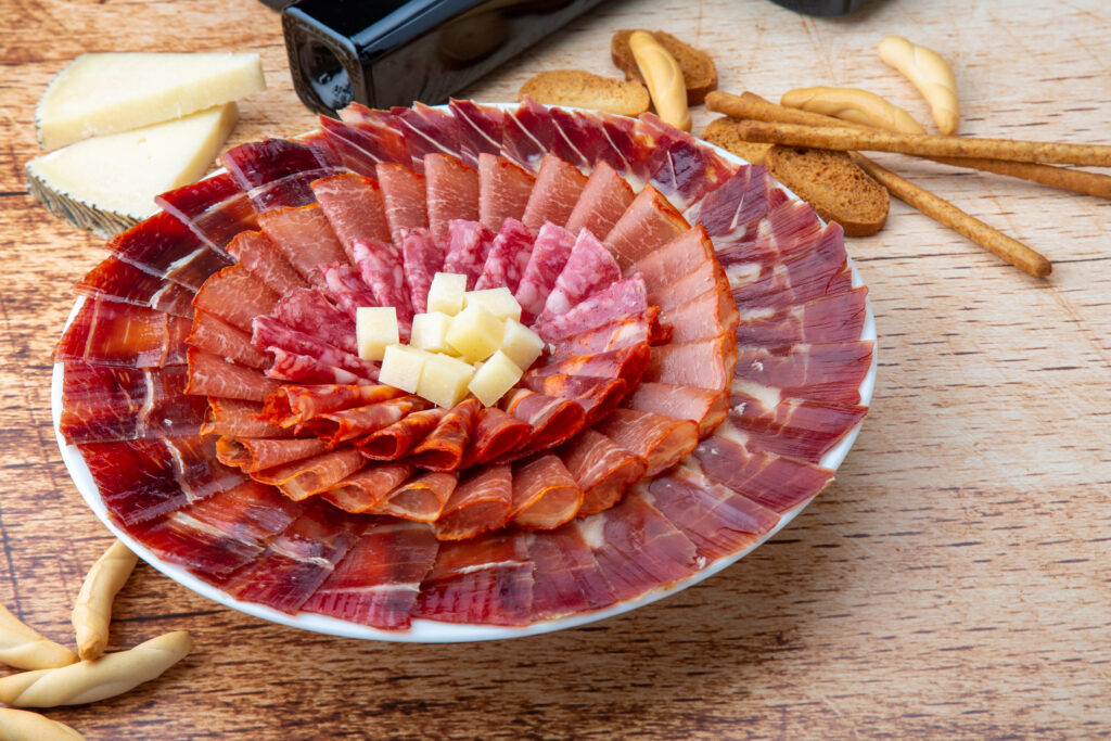 Selección de embutidos gourmet como jamón serrano, lomo, salchichón, chorizo y queso