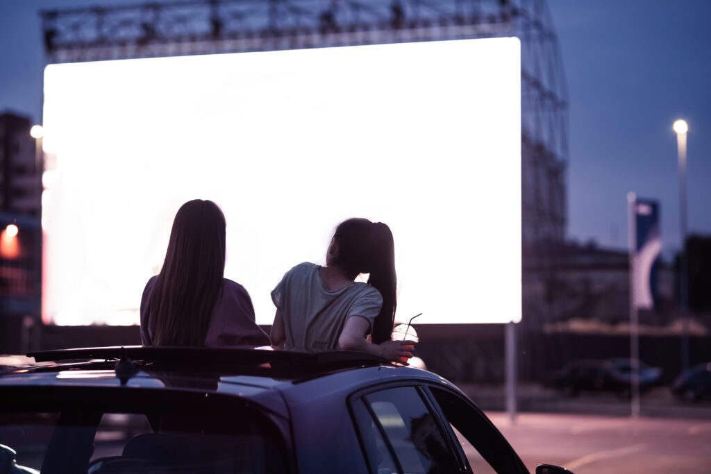 Dos amigas sentadas en el coche en un autocine