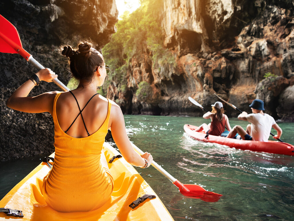 Tres amigos haciendo kayak en un río