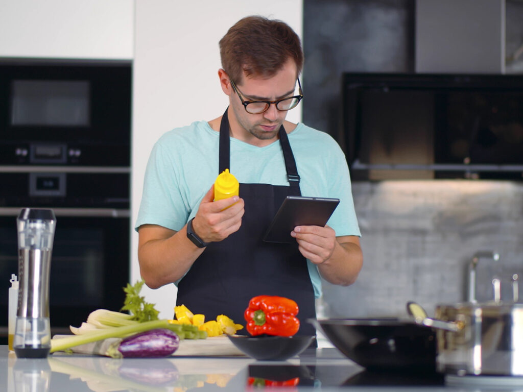 Un hombre en la cocina estudia cómo hacer una receta