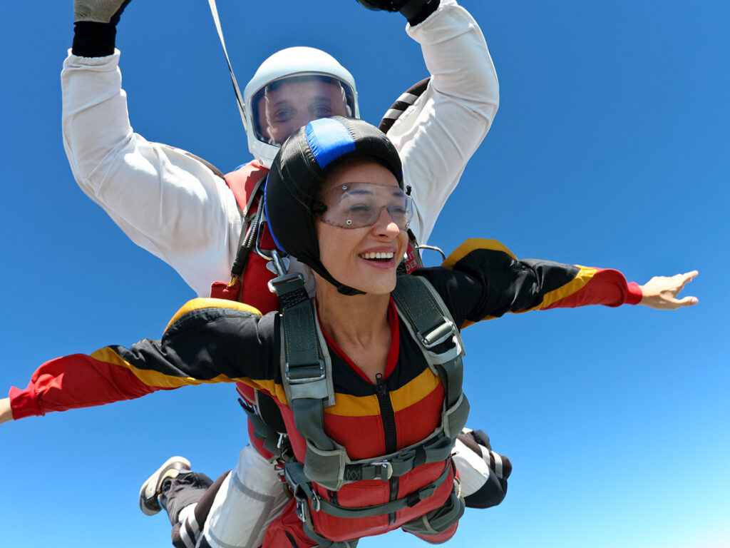 Mujer haciendo paracaidismo junto con un instructor