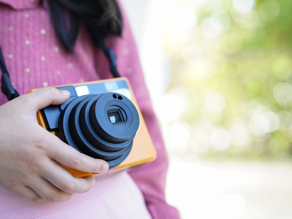 Niña con una cámara de fotos colgada al cuello