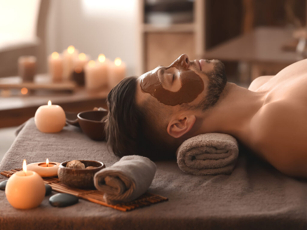 Hombre en spa con mascarilla facial de chocolate