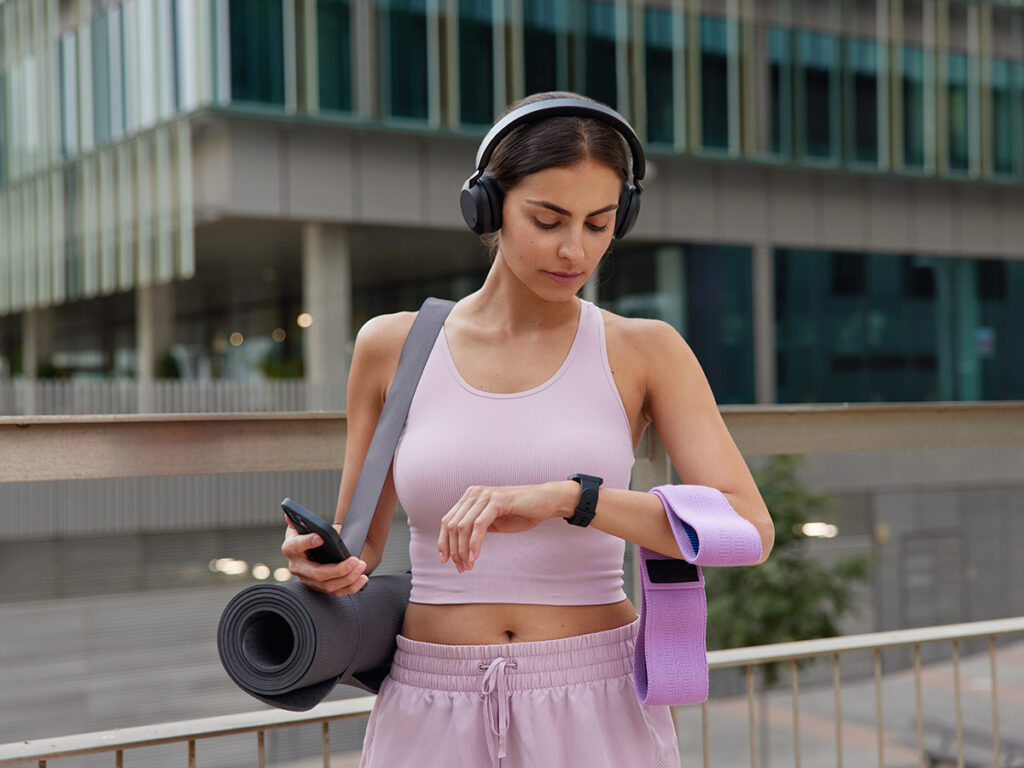 Una chica haciendo deporte con un reloj inteligente y cascos