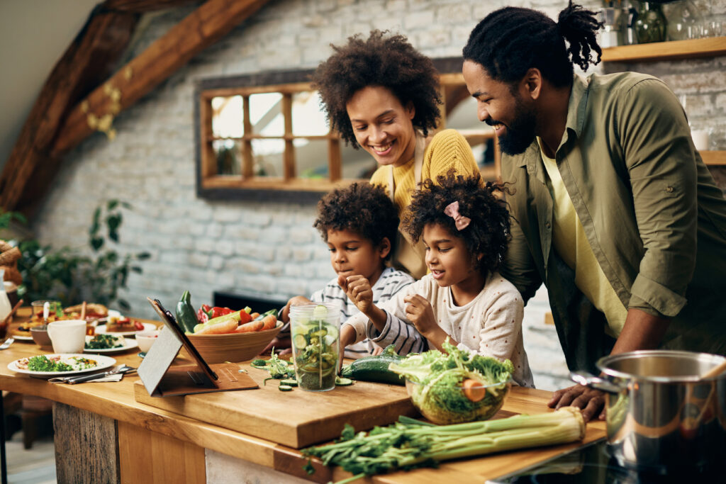 Parents souriants cuisinant avec leurs deux enfants