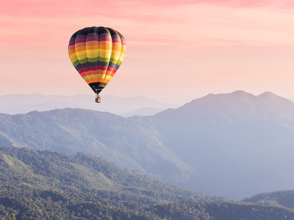 Montgolfière en plein vol au-dessus d’un paysage montagneux