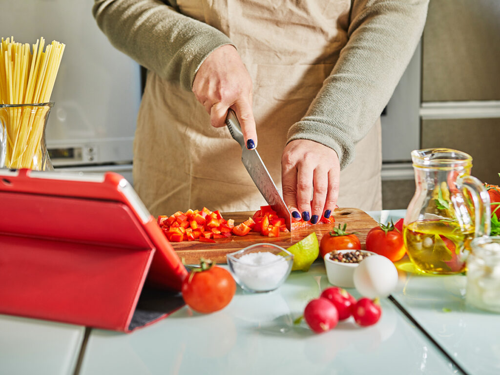 Donna che cucina a casa durante una lezione online