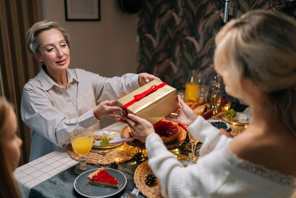 Una donna porge un pacchetto regalo alla suocera